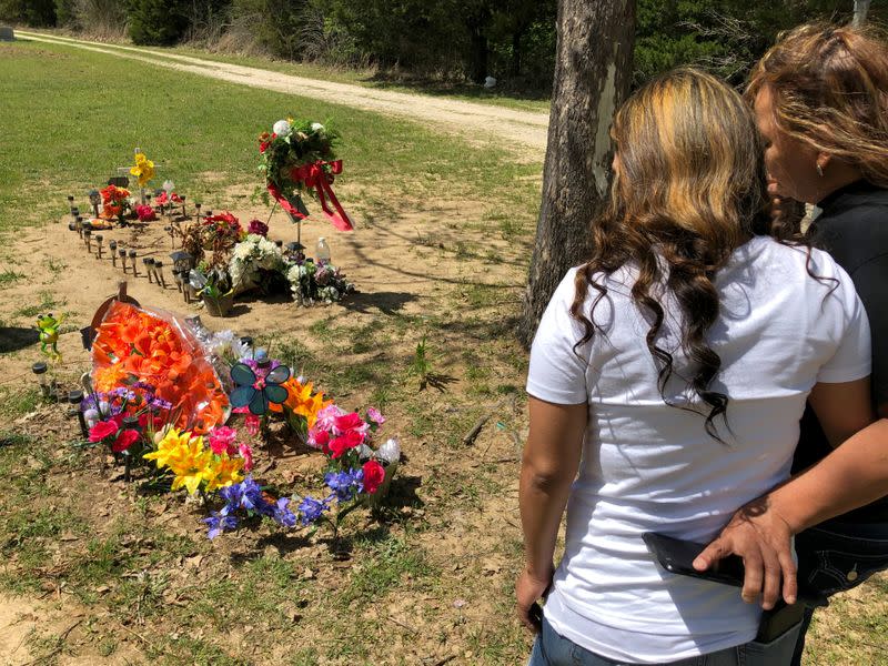 Erma Aldaba and daughter Angie Leija stand near the grave of Aldaba's son Johnny Leija, who died in hospital following an encounter with the police, at a cemetery near Madill, Oklahoma