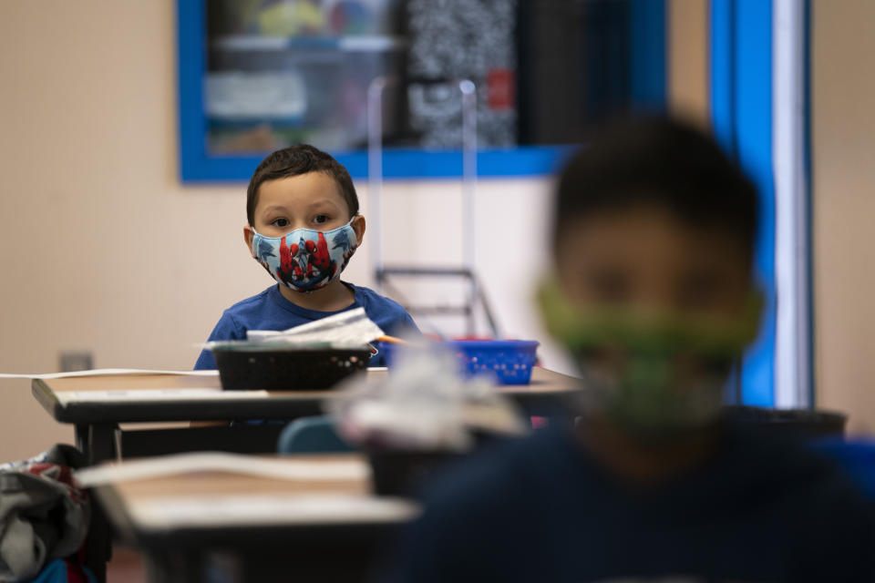 Nathan Ramos sits in a kindergarten classroom on the first day of in-person learning at Maurice Sendak Elementary School in Los Angeles, Tuesday, April 13, 2021. More than a year after the pandemic forced all of California's schools to close classroom doors, some of the state's largest school districts are slowly beginning to reopen this week for in-person instruction. (AP Photo/Jae C. Hong)