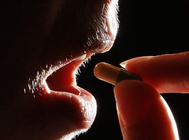 A woman holds the antidepressant drug Prozac, also known as fluoxetine, in Leicester, central England February 26, 2008 in this posed photograph.  REUTERS/Darren Staples