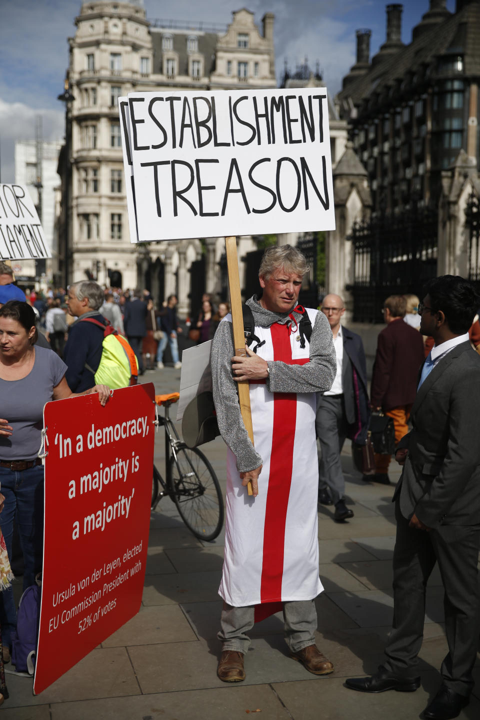 A Brexit supporter holds a placard outside the Houses of Parliament in London, Thursday, Sept. 26, 2019. British Prime Minister Boris Johnson faced a backlash from furious lawmakers Thursday over his use of charged and confrontational language in Parliament about opponents of his Brexit plan. (AP Photo/Matt Dunham)