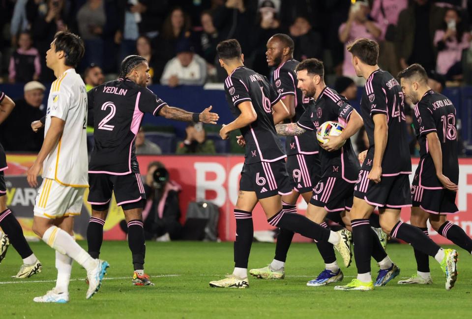 Inter Miami's Lionel Messi, holding the ball, celebrates his game-tying goal against the Galaxy.