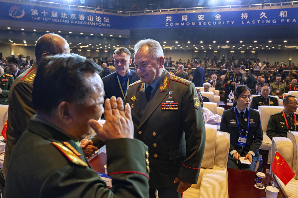 Russian Defense Minister Sergei Shoigu, center, chats with other attendees as he arrives for the opening ceremony of the 10th Beijing Xiangshan Forum in Beijing, Monday, Oct. 30, 2023. Defense Minister Shoigu said Monday the United States is fueling geopolitical tensions to uphold its "hegemony" and warned of the risk of confrontation between major countries. (AP Photo/Ng Han Guan)