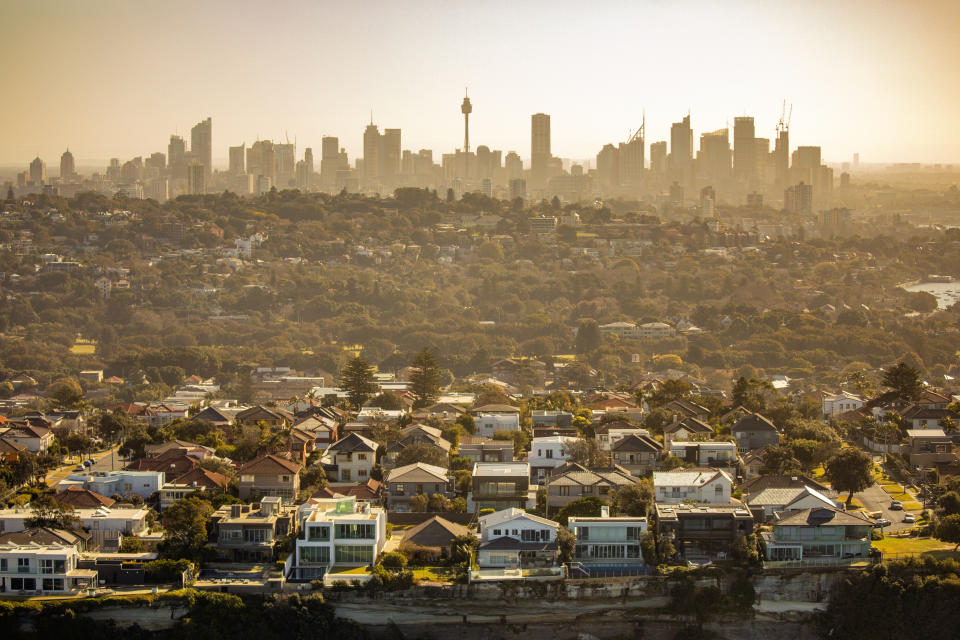 Houses and property on a coastal sea cliff with Sydney city on the horizon.