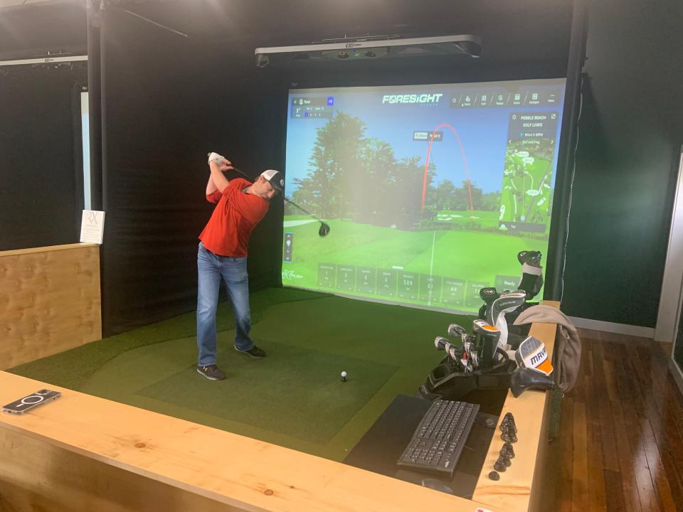 Ryan Satterfield of Vernon, Vt., plays Pebble Beach at Golf RX, an indoor simulator which opened on Main Street in Gardner on Nov. 20.