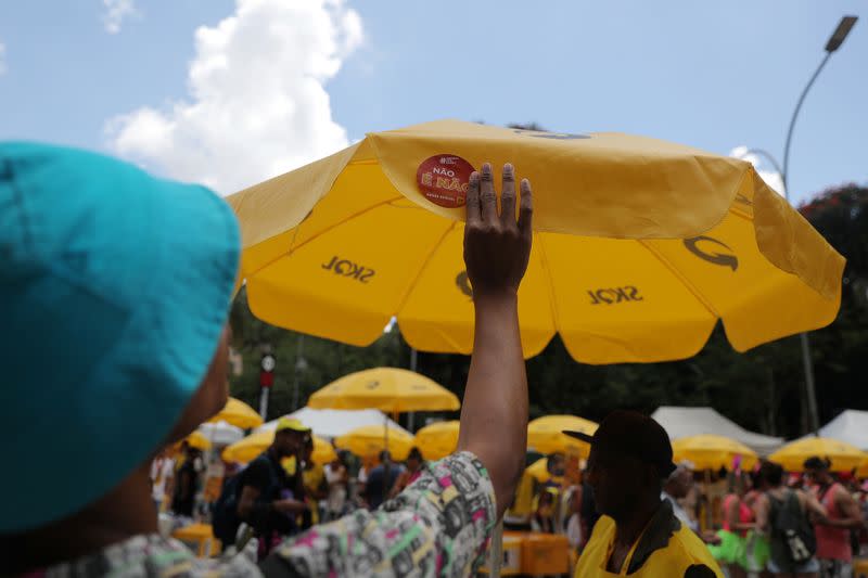 Gabriel Gonçalves, a “Carnival Angel” puts a sticker that reads “No means No” during a carnival block party in Sao Paulo