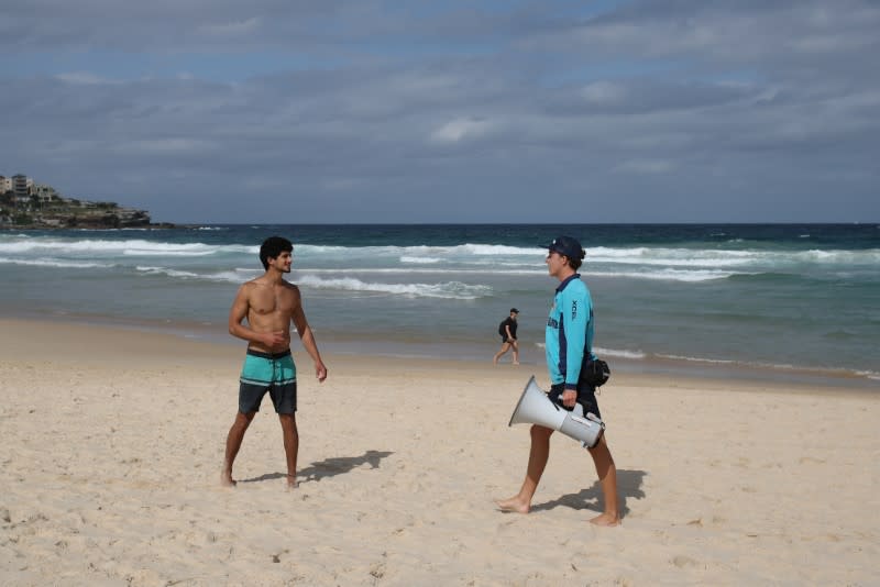 A lifeguard announces the closure of Bondi Beach to prevent the spread of the coronavirus disease (COVID-19) in Sydney