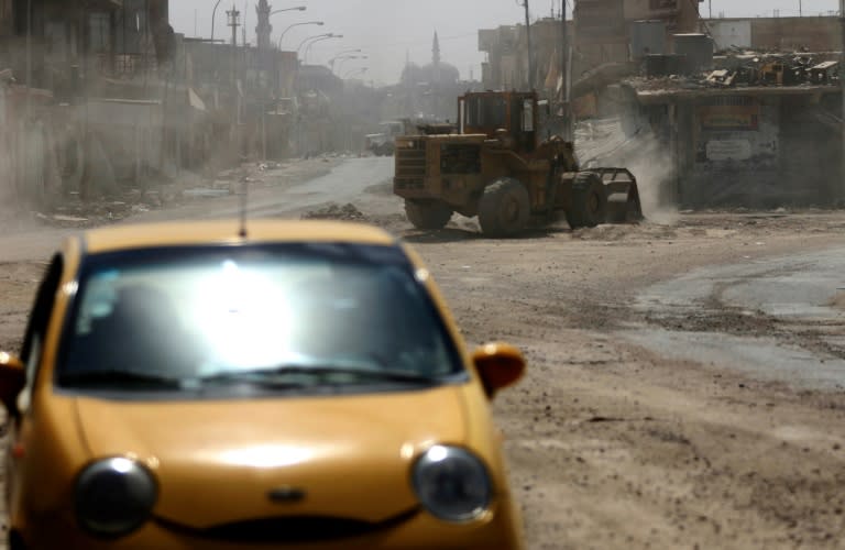 A bulldozer cleans a street on July 13, 2017 as part of efforts to bring west Mosul back to life