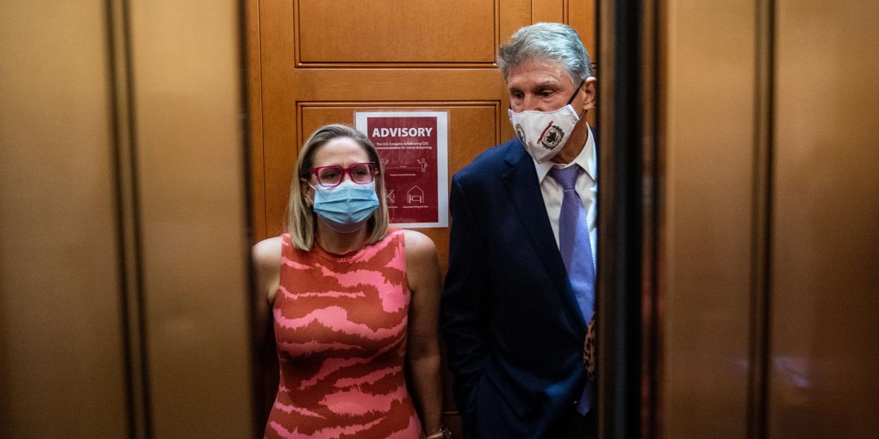 Democratic senators Kyrsten Sinema and Joe Manchin talk in a Senate elevator.