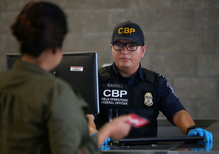 A U.S. Customs and Border Patrol officer interviews people entering the United States from Mexico at the border crossing in San Ysidro, California, U.S. on October 14, 2016. Picture taken on October 14, 2016. REUTERS/Mike Blake