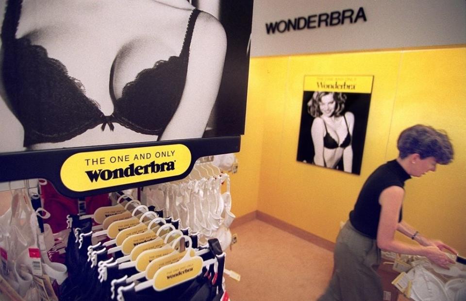 A woman browses through Wonderbra lingerie on display next to promotional posters