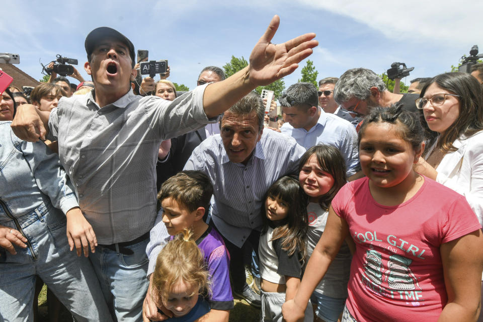 Economy Minister and presidential hopeful Sergio Massa, center back, posses with supporters after voting in the presidential runoff election in Tigre, outskirts of Buenos Aires, Argentina, Sunday, Nov. 19, 2023. (AP Photo/Gustavo Garello)