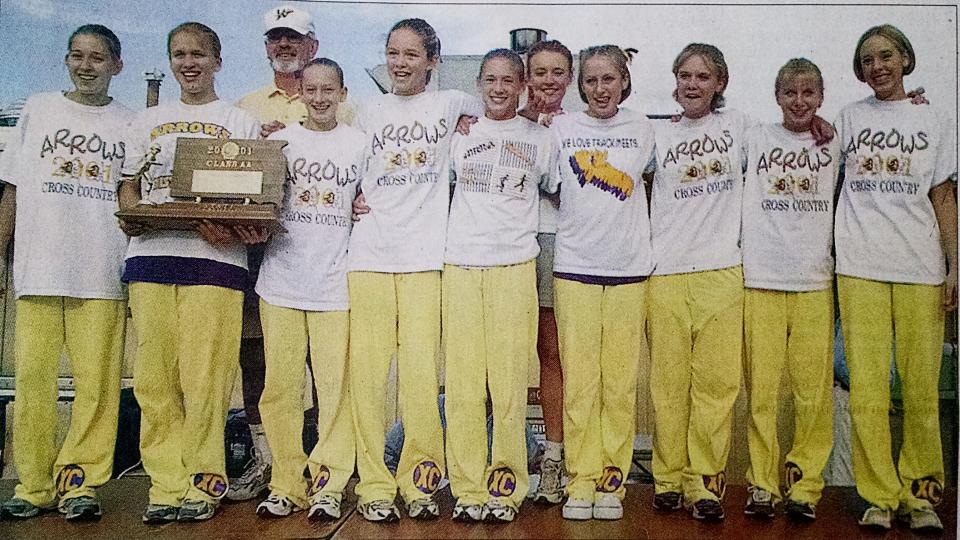 Members of Watertown High School’s girls cross country team pose with the trophy after the Arrows claimed the
2001 state Class AA championship at Rapid City. Team members included, from left, Carrie Mueller, Karle Jacobs, head coach Vic Godfrey, Ashley Engels, Mary Foley, Angie Bauer, assistant coach Tammy Zubke, Caitlin Hiedeman, Kaye O’Hara, Maria O’Hara and Amanda Mueller. The title remains the only state championship in the history of the WHS cross country program.