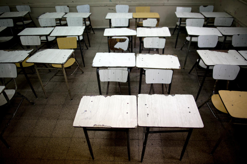 Desks sit empty in a public school classroom in a Buenos Aires suburb, Argentina, Wednesday, March 19, 2014. Striking teachers in the Buenos Aires province are demanding a wage increase higher than what is currently being offered by the provincial administration. The strike is in its 11th day, affecting more than 3 million students. (AP Photo/Natacha Pisarenko)