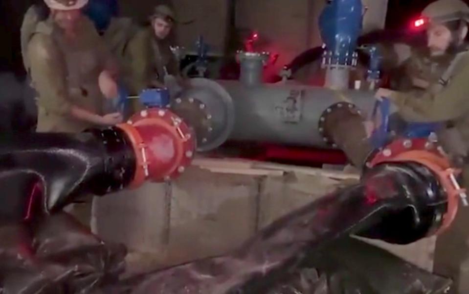 Soldiers work to connect water pumps to begin operation in Gaza tunnels