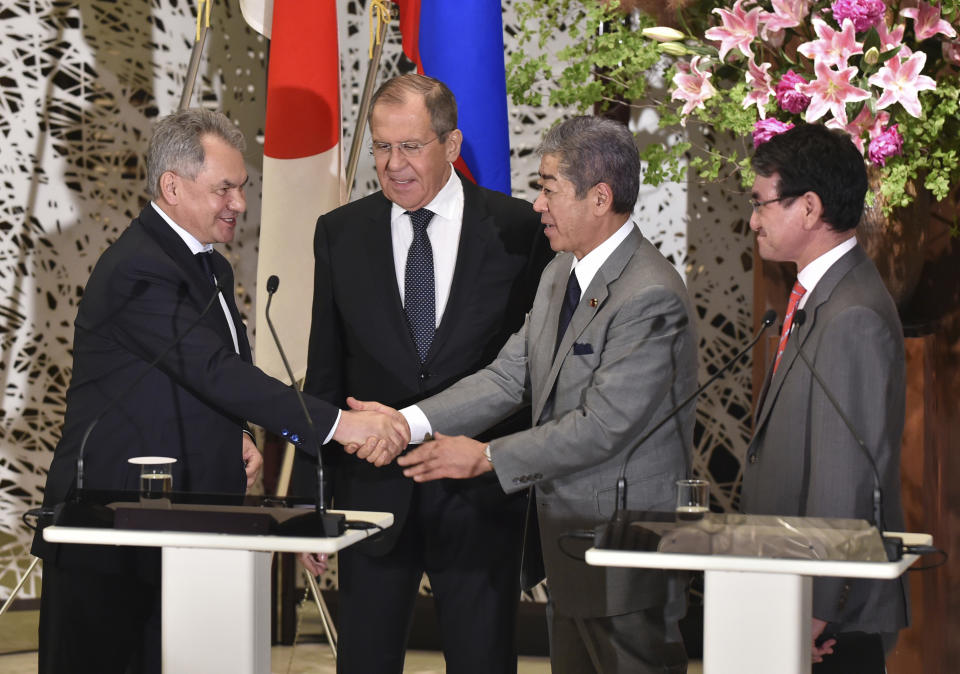 Japan's Defence Minister Takeshi Iwaya, second right, shakes hands with Russia's Defence Minister Sergei Shoigu, left, while Japan's Foreign Minister Taro Kono, right, and Russia's Foreign Minister Sergei Lavrov, second left, look on after their 2+2 joint press conference at the Iikura Guest House in Tokyo, Thursday, May 30, 2019. (Kazuhiro Nogi/Pool Photo via AP)