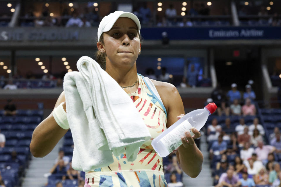 Madison Keys, of the United States, takes water and towels to a security guard for a patron that was having a medical issue during Keys' quarterfinals match against Marketa Vondrousova, of the Czech Republic, of the U.S. Open tennis championships, Wednesday, Sept. 6, 2023, in New York (AP Photo/Jason DeCrow)