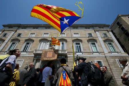 FILE PHOTO: A man waves an "Estelada", Catalan separatist flag, outside the Generalitat Palace in Barcelona, Spain, May 17, 2018. REUTERS/Albert Gea