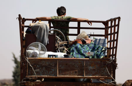A man rides on a truck with belongings in Deraa countryside, Syria June 22, 2018. REUTERS/Alaa al-Faqir
