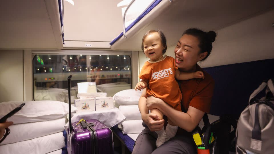 A passenger with a child boards the high-speed sleeper train in Beijing for its inaugural journey to Hong Kong's West Kowloon Station. - Jia Tianyong/China News Service/VCG/Getty Images