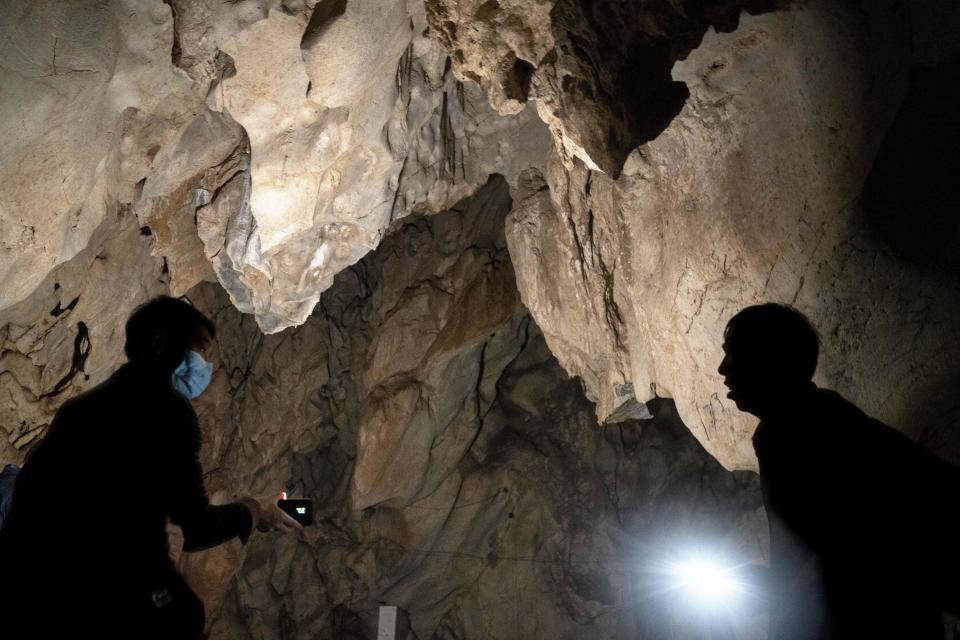 Visitors look inside the abandoned Wanling cave in southern China's Yunnan province on Dec. 2, 2020. Contact between bats and people alarms scientists as a potential source of disease outbreaks. / Credit: Ng Han Guan / AP