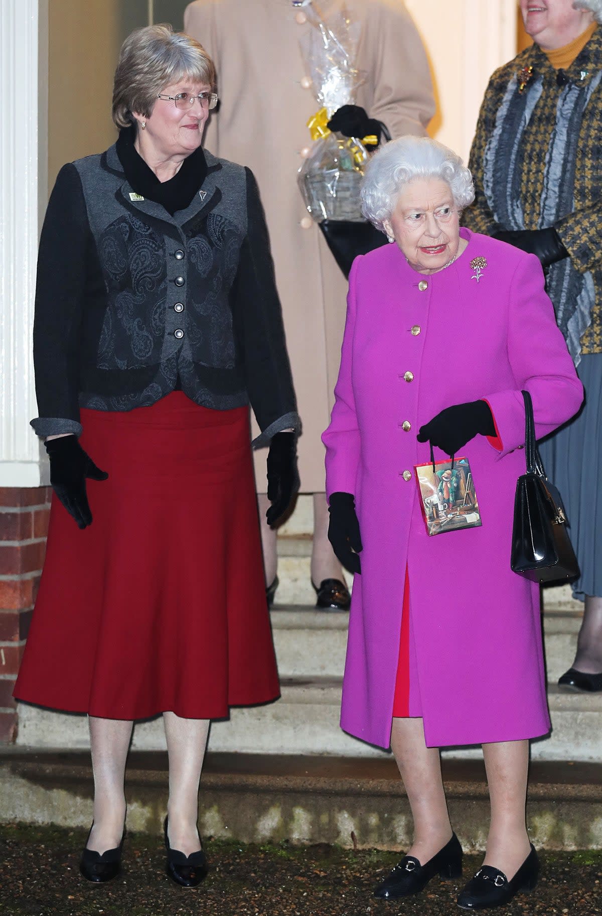 Queen Elizabeth II with Vice President Yvonne Browne (left) as she leaves West Newton village hall in Norfolk after attending a meeting of the Sandringham Women’s Institute (Chris Radburn/PA) (PA Archive)