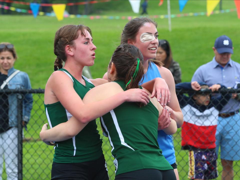 Seniors Sydney Leitner (l) of Yorktown, Adriano Catalano (c) of Pleasantville and Daphne Banino (r, in blue) of Ursuline embrace after the girls 3,000-meter run during day 1 of the Westchester County track & field championships at Horace Greeley High School in Chappaqua on Friday, May 20, 2022.