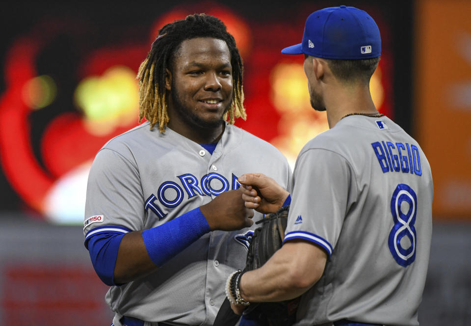 BALTIMORE, MD - JUNE 12: Toronto Blue Jays third baseman Vladimir Guerrero Jr. (27) fist pumps with second baseman Cavan Biggio (8) after the third inning during the game between the Toronto Blue Jays and the Baltimore Orioles on June 12, 2019, at Orioles Park at Camden Yards in Baltimore, MD.  (Photo by Mark Goldman/Icon Sportswire via Getty Images)