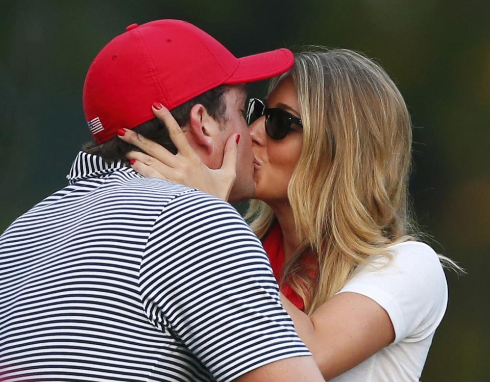 U.S. golfer Keegan Bradley gets a kiss from his girlfriend Jillian Stacey after he and teammate Phil Mickelson defeated the International team of Jason Day, of Australia, and Graham DeLaet, of Canada, during the Foursome matches for the 2013 Presidents Cup golf tournament at Muirfield Village Golf Club in Dublin, Ohio October 4, 2013. REUTERS/Chris Keane (UNITED STATES - Tags: SPORT GOLF)