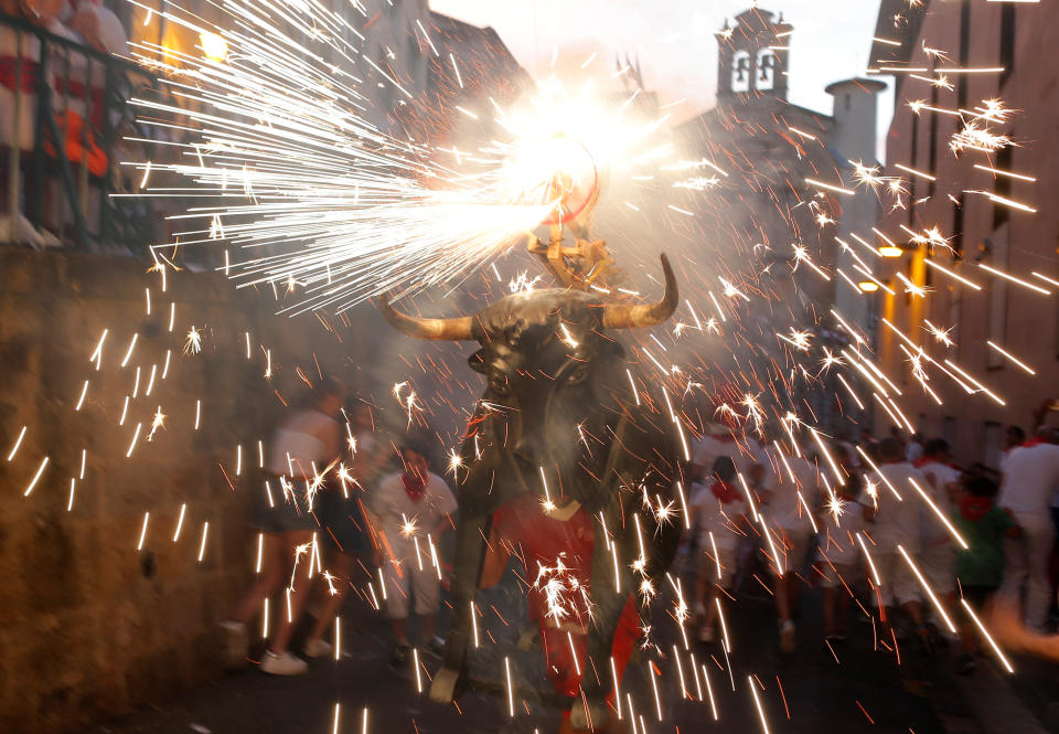 Revellers run next to the Fire Bull, a man carrying a bull figure packed with fireworks, during the San Fermin festival in Pamplona, Spain, July 7, 2019. (Photo: Jon Nazca/Reuters)