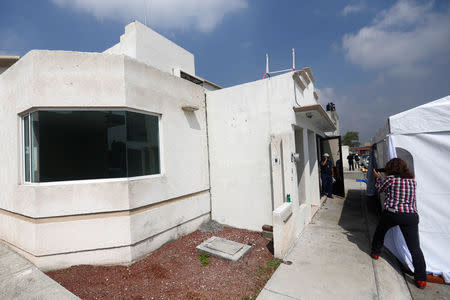 A journalist films outside of a house where eleven people were found dead at Villa de los Milagros residential park, in the city of Tizayuca in Mexican state of Hidalgo, Mexico, July 13, 2017. REUTERS/Edgard Garrido