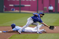 Kansas City Royals Whit Merrifield, left, steals a base behind Toronto Blue Jays second baseman Marcus Semien, right, during the first inning of a baseball game at Kauffman Stadium in Kansas City, Mo., Sunday, April 18, 2021. (AP Photo/Orlin Wagner)