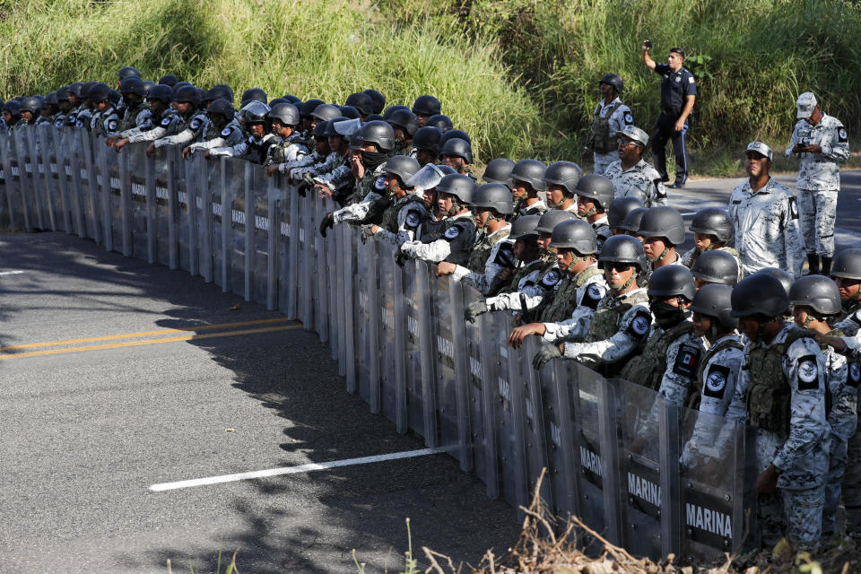 Mexican National Guardsmen block the passage of migrants on the highway leading to Tapachula, Mexico, Thursday, Jan. 23, 2020. Hundreds of Central American migrants crossed the Suchiate River into Mexico from Guatemala Thursday after a days-long standoff with security forces. (AP Photo/Marco Ugarte)