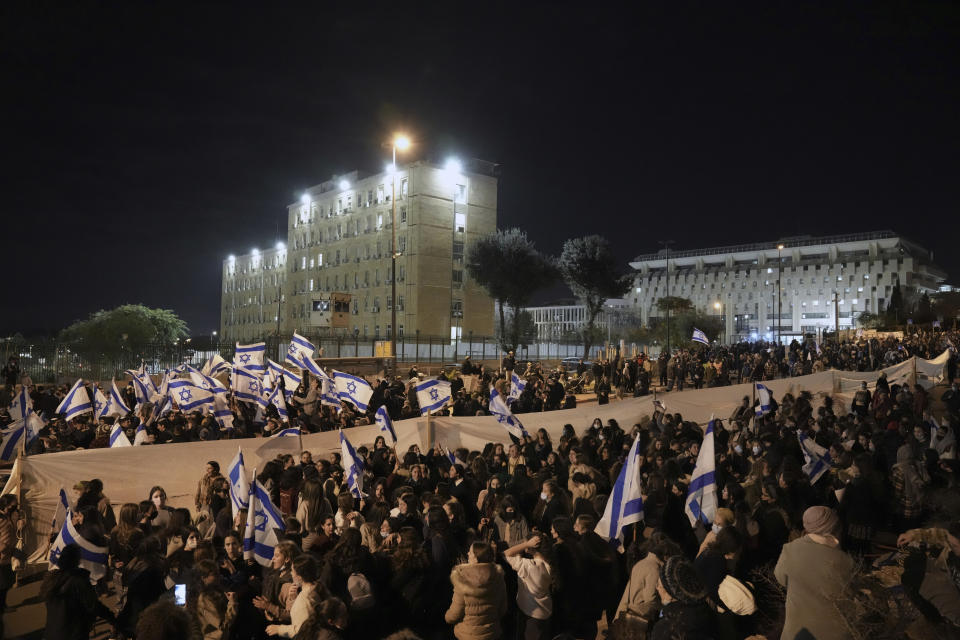 Thousands of Israeli nationalists protest outside the parliament building in Jerusalem, calling on the government not to demolish a West Bank settlement outpost, Thursday, Jan. 13, 2022. (AP Photo/Ariel Schalit)