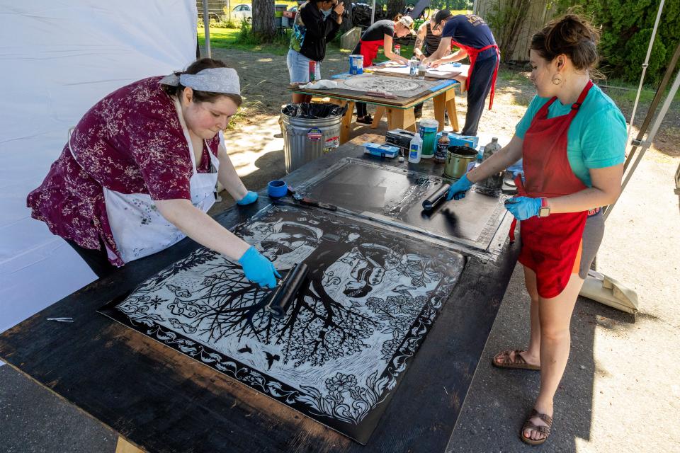 Rosie Bromberg, left, and Terra Tapia, right, ink a linoleum template at Wayzgoose Kitsap 2022 on Saturday.