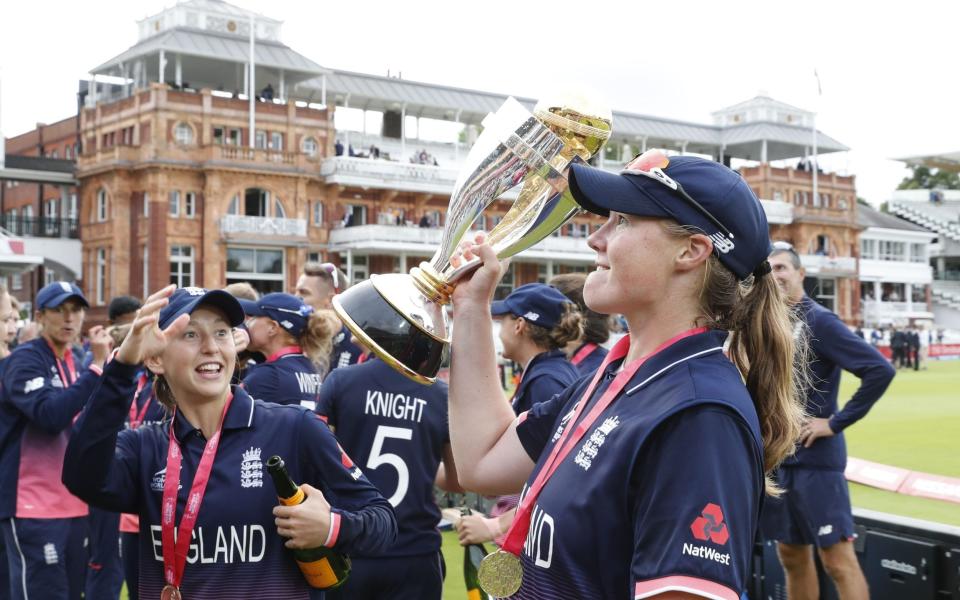 England's Anya Shrubsole (R) raises the trophy after winning the ICC Women's World Cup cricket final between England and India at Lord's cricket ground in London on July 23, 2017 - AFP