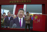 A visitor poses for a photograph in front of a TV showing Chinese president Xi Jinping at an exhibition to mark the 25th anniversary of the former British colony's return to Chinese rule, in Hong Kong, Friday, June 24, 2022. Hong Kong authorities, citing "security reasons," have barred more than 10 journalists from covering events and ceremonies this week marking the 25th anniversary of Hong Kong's return to China, according to the Hong Kong Journalists Association. (AP Photo/Kin Cheung)
