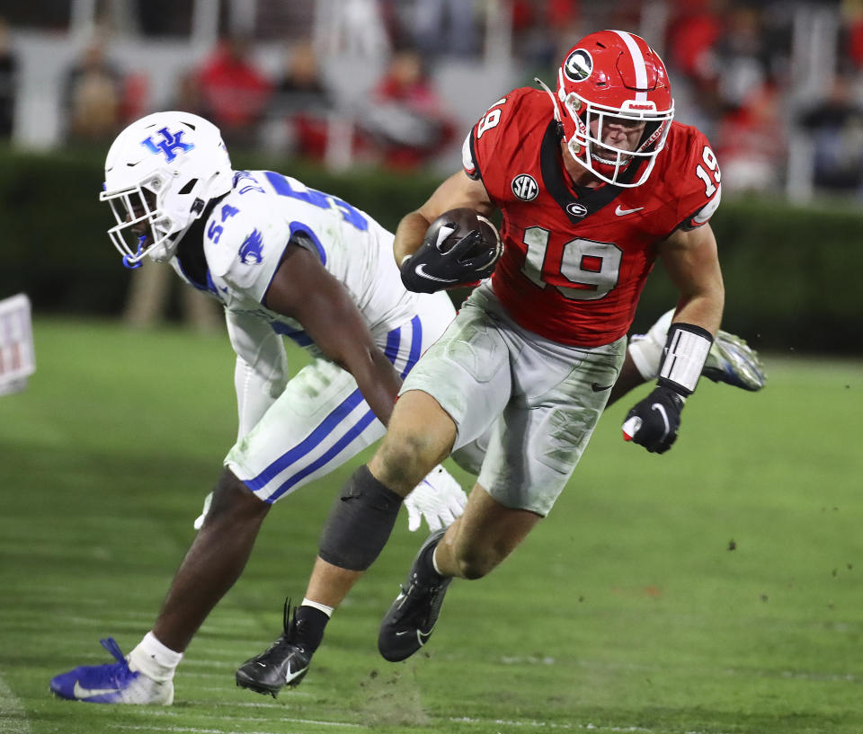Georgia tight end Brock Bowers runs for a first down past Kentucky linebacker D'Eryk Jackson during the third quarter of an NCAA college football game Saturday, Oct. 7, 2023, in Athens, Ga. (Curtis Compton/Atlanta Journal-Constitution via AP)