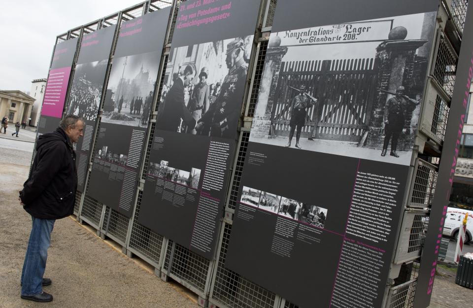 A man looks at panels detailing the Nazi's rise to power near Berlin's Brandenburg Gate January 29, 2013, to coincide with the 80th anniversary of Adolf Hitler's accession to power January 30, 1933. (JOHN MACDOUGALL/AFP/Getty Images)