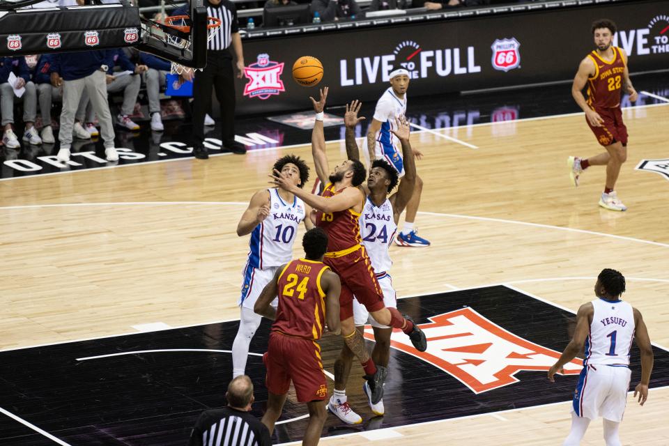 Iowa State guard Jaren Holmes (13) shoots the ball while defended by Kansas forwards Jalen Wilson (10) and KJ Adams Jr. (24) in the first half Friday at the T-Mobile Center in Kansas City during the Big 12 Conference tournament.