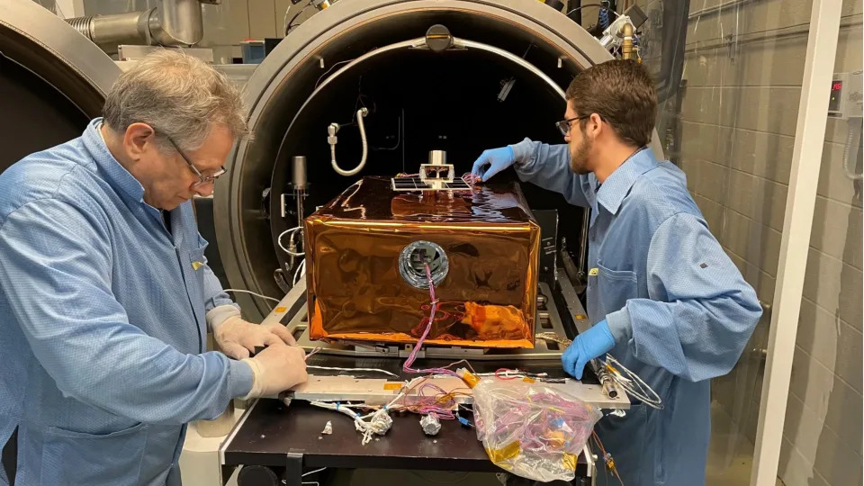 two people in a lab adjust the settings on a piece of scientific equipment during a test