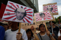 Pro-China protesters carry printouts depicting legislator-elects Baggio Leung (L, R) and Yau Wai-ching (C) as traitors during a demonstration outside the Legislative Council in Hong Kong, China October 26, 2016. REUTERS/Bobby Yip