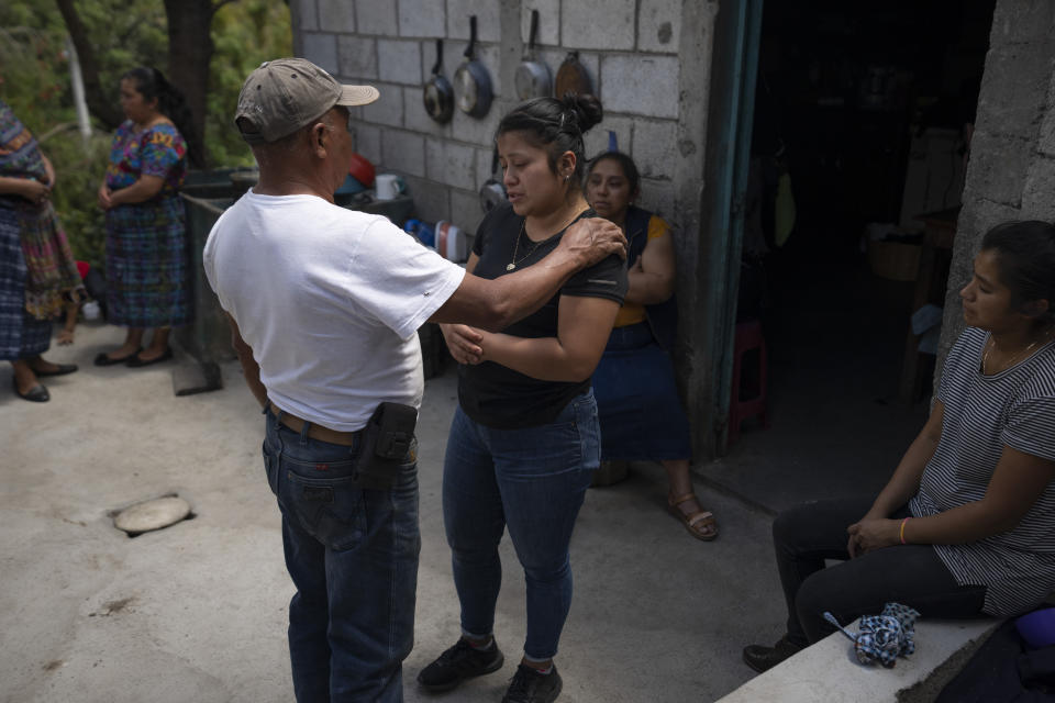 Silvia Sutuj, the daughter of Guatemalan migrant Bacilio Sutuj Saravia who died in the recent fire at a Mexican migrant detention center, is consoled by a neighbor at her home in San Martin Jilotepeque, Guatemala, Wednesday, March 29, 2023. According to Mexican President Andres Manuel Lopez Obrador, migrants fearing deportation set mattresses ablaze late Monday at the center, starting a fire that left more than three dozen dead. (AP Photo/Moises Castillo)