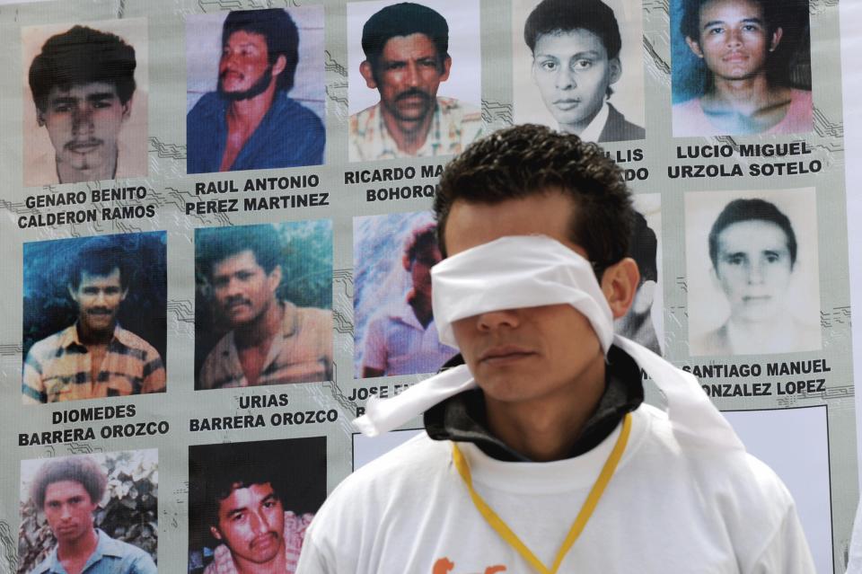 A relative of a person disappeared by the Colombian AUC paramilitary guerrillas, wearing a blindfold, demonstrates against the government during a protest on July 8, 2008, in Bogota. The protesters request a better treatment from the government and to be given information about where the bodies of their beloved ones are.