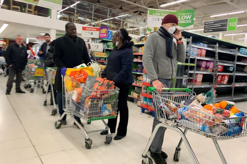 Shoppers queue at a supermarket in London