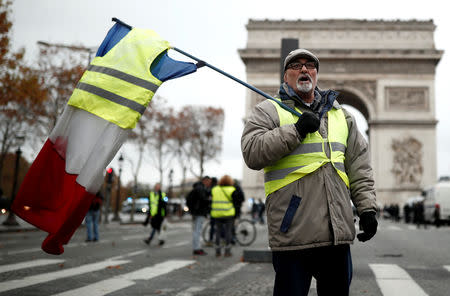 A protesters wearing yellow vest, a symbol of a French drivers' protest against higher fuel prices, shouts out slogans on the Champs-Elysee in Paris, France, November 24, 2018. REUTERS/Benoit Tessier