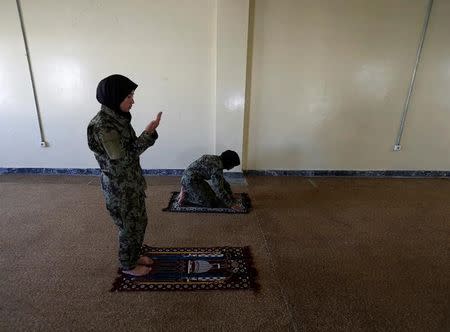 Female soldier Aghama Dehqanyar, 19 (L), prays inside a mosque at the Kabul Military Training Centre (KMTC) in Kabul, Afghanistan October 26, 2016. REUTERS/Mohammad Ismail