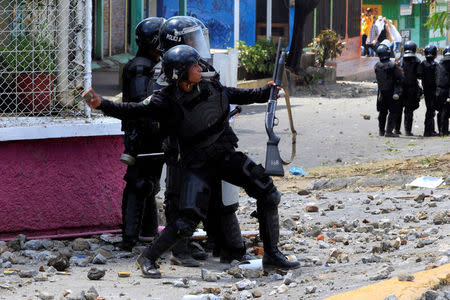 A riot policeman throws a rock toward university students during a protest against the reforms that implement changes to the pension plans of the Nicaraguan Social Security Institute (INSS) in Managua, Nicaragua April 19,2018.REUTERS/Oswaldo Rivas