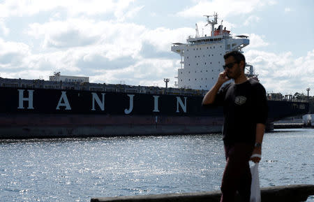 A pedestrian walks past the container ship 'Hanjin California' moored to a dock in Sydney Harbour, September 12, 2016. REUTERS/Jason Reed