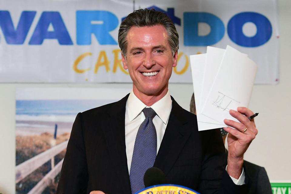 California Gov. Gavin Newsom displays the seven bills signed to support the state's expansion of mental health services in Los Angeles, California on Sept. 29, 2021. Newsom also signed into law legislation designed to reform the state’s legal guardianship laws that critics say have led to exploitation.