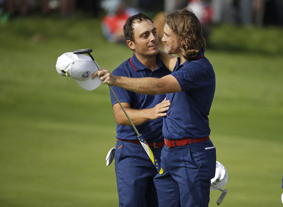 Europe's Francesco Molinari, left, and Europe's Tommy Fleetwood embrace after beating Tiger Woods of the US and Patrick Reed in their fourball match on the opening day of the 42nd Ryder Cup at Le Golf National in Saint-Quentin-en-Yvelines, outside Paris, France, Friday, Sept. 28, 2018. (AP Photo/Matt Dunham)